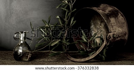 Olive oil and old copper pot and olive leaves on dark background Royalty-Free Stock Photo #376332838