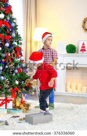 Two cute small brothers decorating Christmas tree