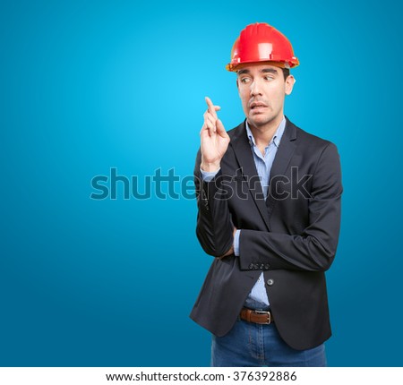 Worried architect with crossed fingers gesture