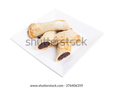 Russian pancakes stuffed with poppy seeds and covered with sugar powder. Isolated on a white background.