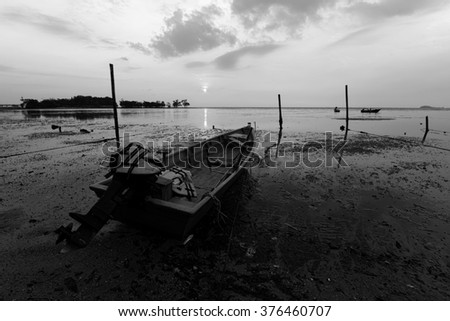 Fisherman's boat park at the beach during sunset. Black and white photograph.