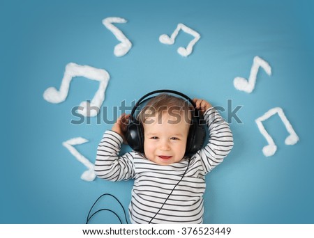 little boy on blue blanket background with headphones