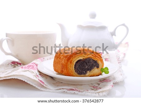bun with poppy seeds on a plate on a white background