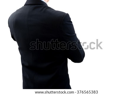 Isolated back side of businessman in dark gray suit standing and crossing one's arm. He is looking for new opportunity and business success