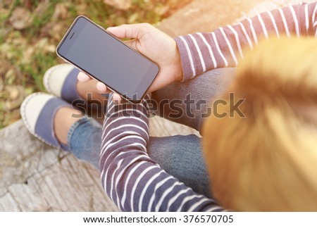 hipster female holding smart phone similar to iphone6 outdoor lifestyle Royalty-Free Stock Photo #376570705