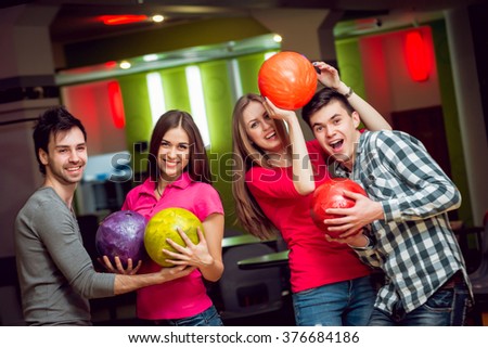 Cheerful friends at the bowling alley with the balls