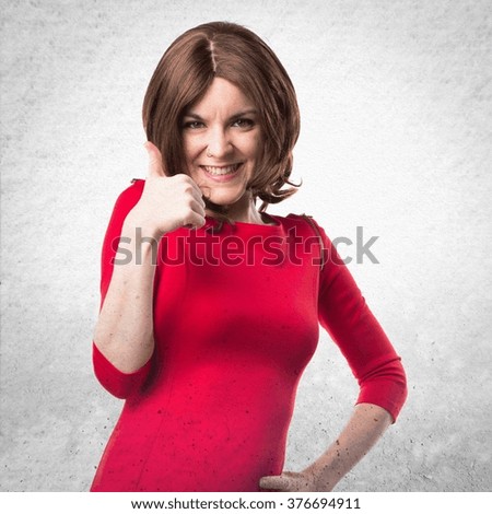 Brunette woman with thumb up over textured background
