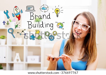 Brand building concept with young woman wearing white glasses using her smartphone in her home 