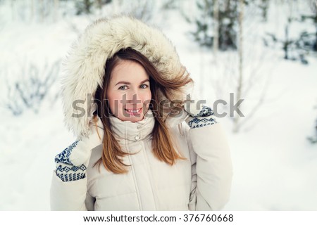 Christmas girl outdoor portrait. Woman in winter clothes on a snow field. Toned picture