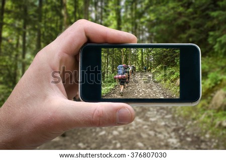 shot of a man's hand holding a smartphone, mountain scenery, nature in the mountain heights Photo by man photographed on a smartphone, the spring in the mountains