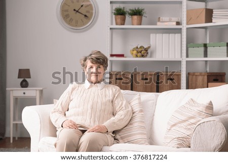Older elegant woman sitting alone at home