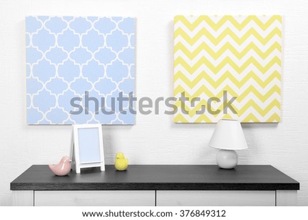 Photo frame and decorations on table with pictures in light room