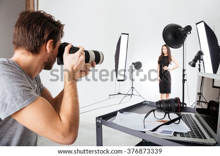 Photographer shooting model in studio with softboxes Royalty-Free Stock Photo #376873339