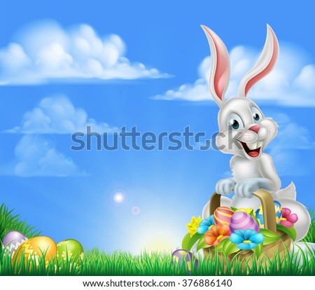 White Easter bunny with a basket full of decorated chocolate Easter eggs in a field 