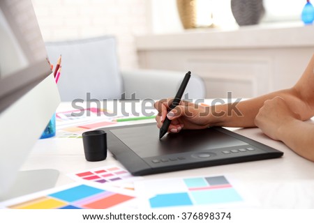 Artist drawing on graphic tablet in office Royalty-Free Stock Photo #376898374