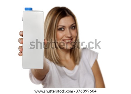 happy young woman holds in her hand carton with milk