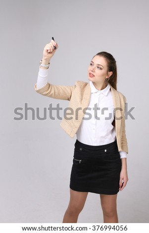 young woman with pen on grey background