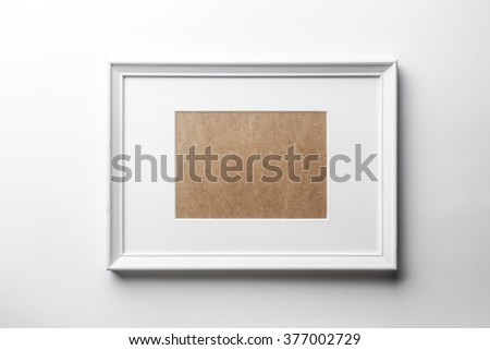 White plain empty wood picture frame with white mat passe-partout on white wall background