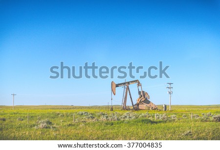 Oil Pump Oil Rig Energy in countryside with blue sky background.
