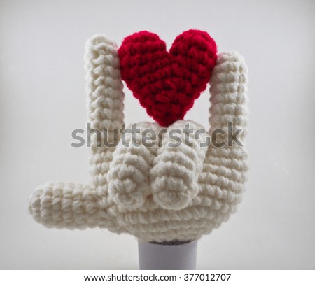The sign of love, knitting wool in fingers and heart shape, a special gift on valentine's day.