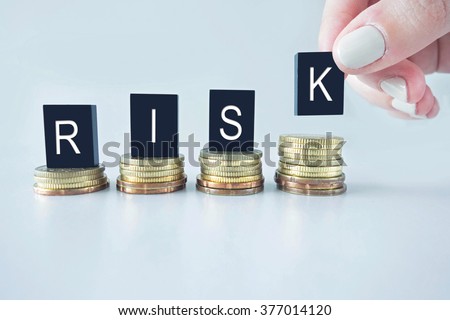 Risk text stacked upward on coins with cool image temperature as High Risk Business Concept Royalty-Free Stock Photo #377014120