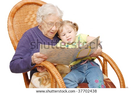 Grandmother reads to the granddaughter in an armchair