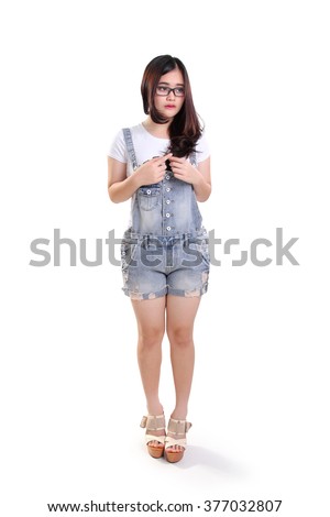 Full length portrait of cute shy nerdy girl standing awkwardly, isolated on white background