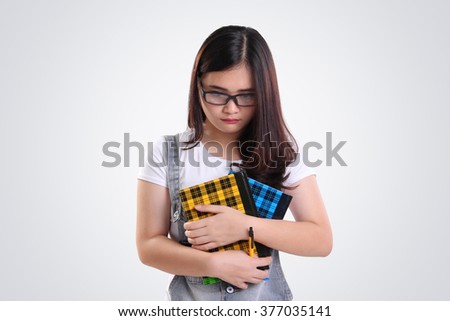 Nerdy Asian school girl looking down with sad depressed face, on white background