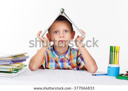 Tired boy with a book on his head