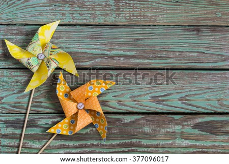 Homemade paper pinwheel on a wooden rustic background . Vintage and rustic style