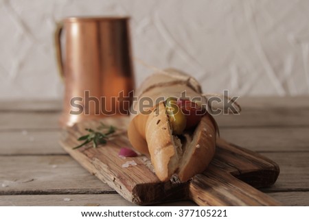 Hot dog with sausage and beer and red hot pepper on a brown background propki