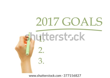 Woman hand writing 2017 Goals List on a transparent wipe board
