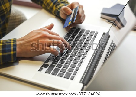 Laptop and man who working and hold in hand credit card