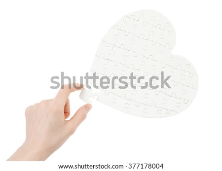 Incomplete jigsaw puzzle in a shape of a heart isolated on white