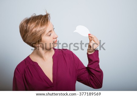 Bright woman holding a white sticker, studio isolated