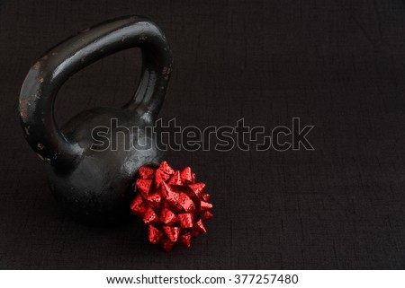 Black kettle bell with a red bow on a black background
 Royalty-Free Stock Photo #377257480