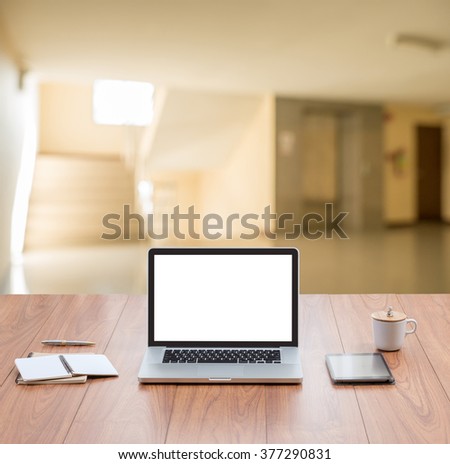 Laptop computer on wood table top with blur home interior