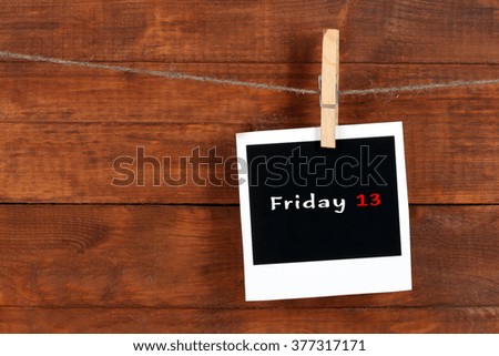 Photo paper with text Friday 13 on wooden background
