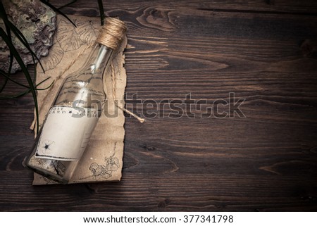 Message in a bottle on old paper with copy space on tropical  wooden background