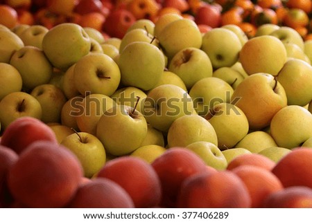Many clean organic natural fresh tasty ripe yellow apples smooth skin crop fruit full of vitamin for healthy eating for sale on blurred peach background, horizontal picture