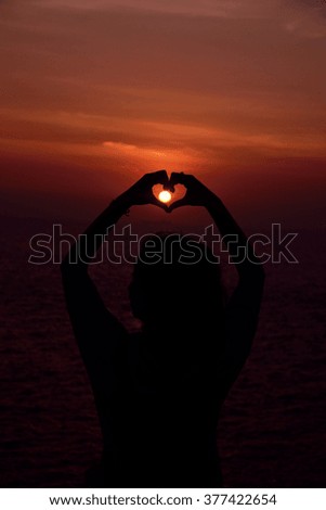holding hand love sign sunset background