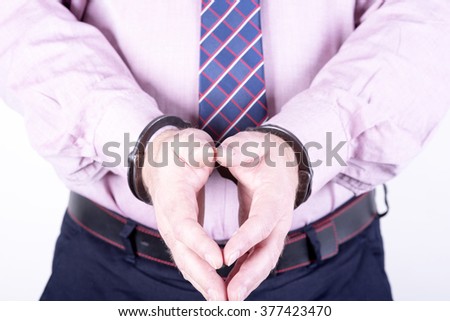 a picture of a businessman locked in handcuffs