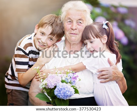 Closeup summer portrait of happy grandmother with grandchildren outdoors Royalty-Free Stock Photo #377530423