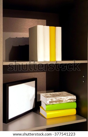 Books and a picture frame on the shelf 
