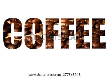 Word COFFEE over coffee beans on wooden background.