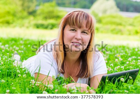 Woman in green grass with flowers horizontal picture