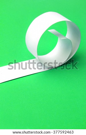 Cutted and rolled white paper with green  background