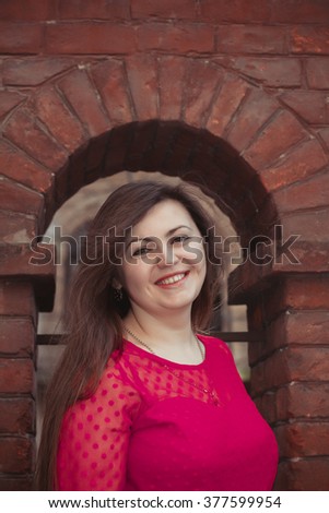 Pretty young woman near an arch on a building