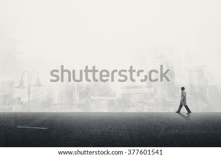 man walking on the grey street in city