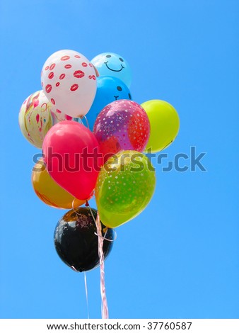 Bunch of colored party balloons against blue sky background